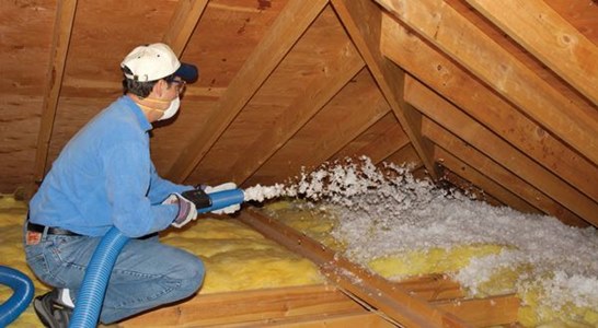 Man installing fiberglass insulation